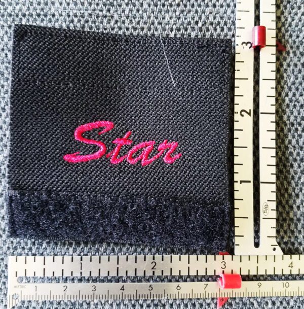 A black fabric with red writing and a ruler