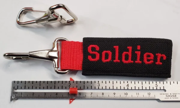 A key chain with the word soldier on it.