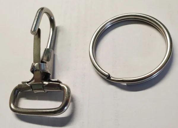 A metal ring and a carabiner on top of a table.